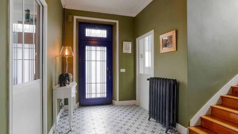 vue intérieur d'une maison avec une porte d'entrée sur mesure en bois ouverte
